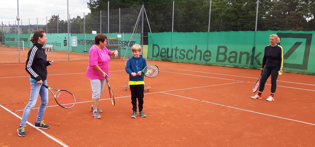 Zwei Girls besteigen den Trainer am deutschen Tennisplatz